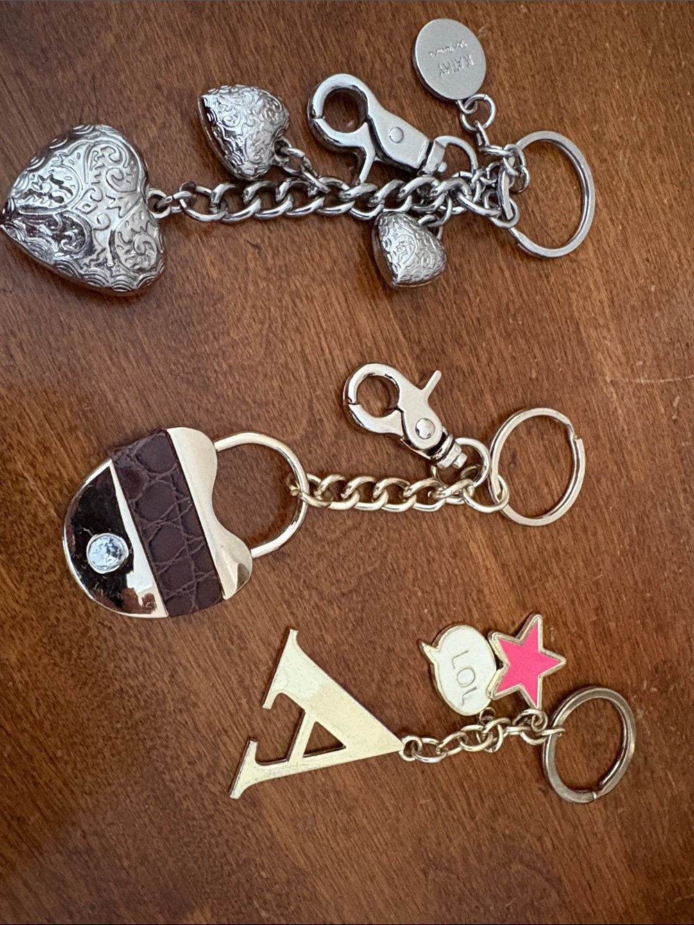 Kathy Van Zeeland Gold and Silver Keychain Trio with Brown Purse and Pink Star